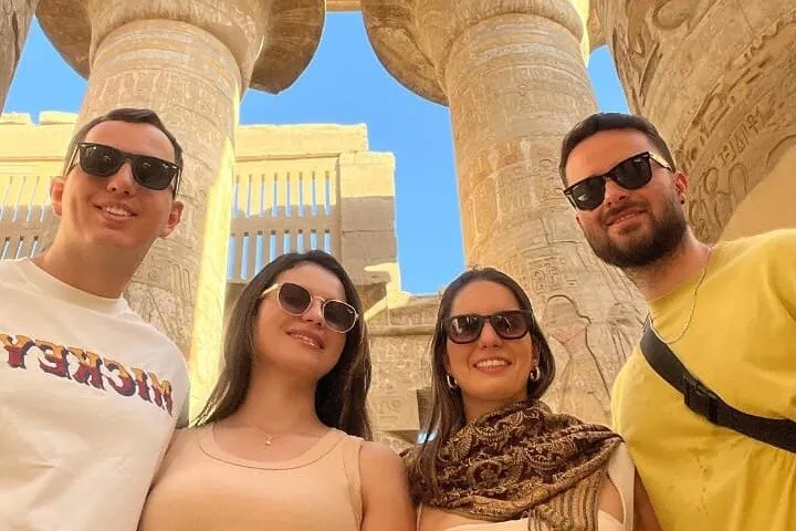 Four travelers among temple columns on a private 5-star Nile cruise, a luxury Egypt tour, Luxor, Egypt