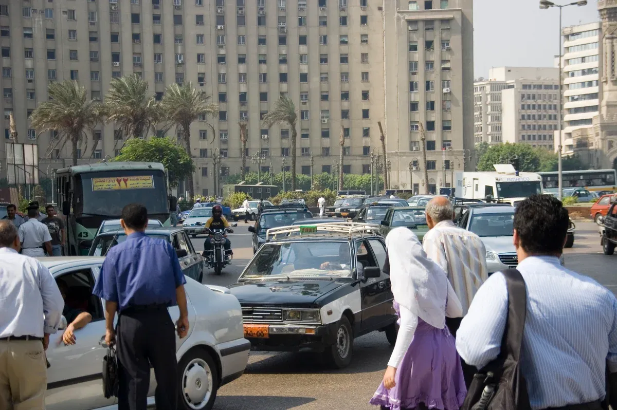 A busy Cairo street with taxis, buses and pedestrians on a luxury Egypt tour, Downtown Cairo, Egypt