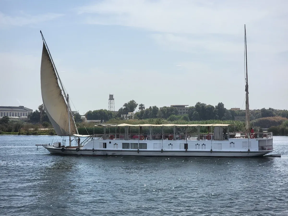 A dahabiya sailing boat with a lateen sail on the Nile on a luxury Egypt tour, Nile River, Egypt