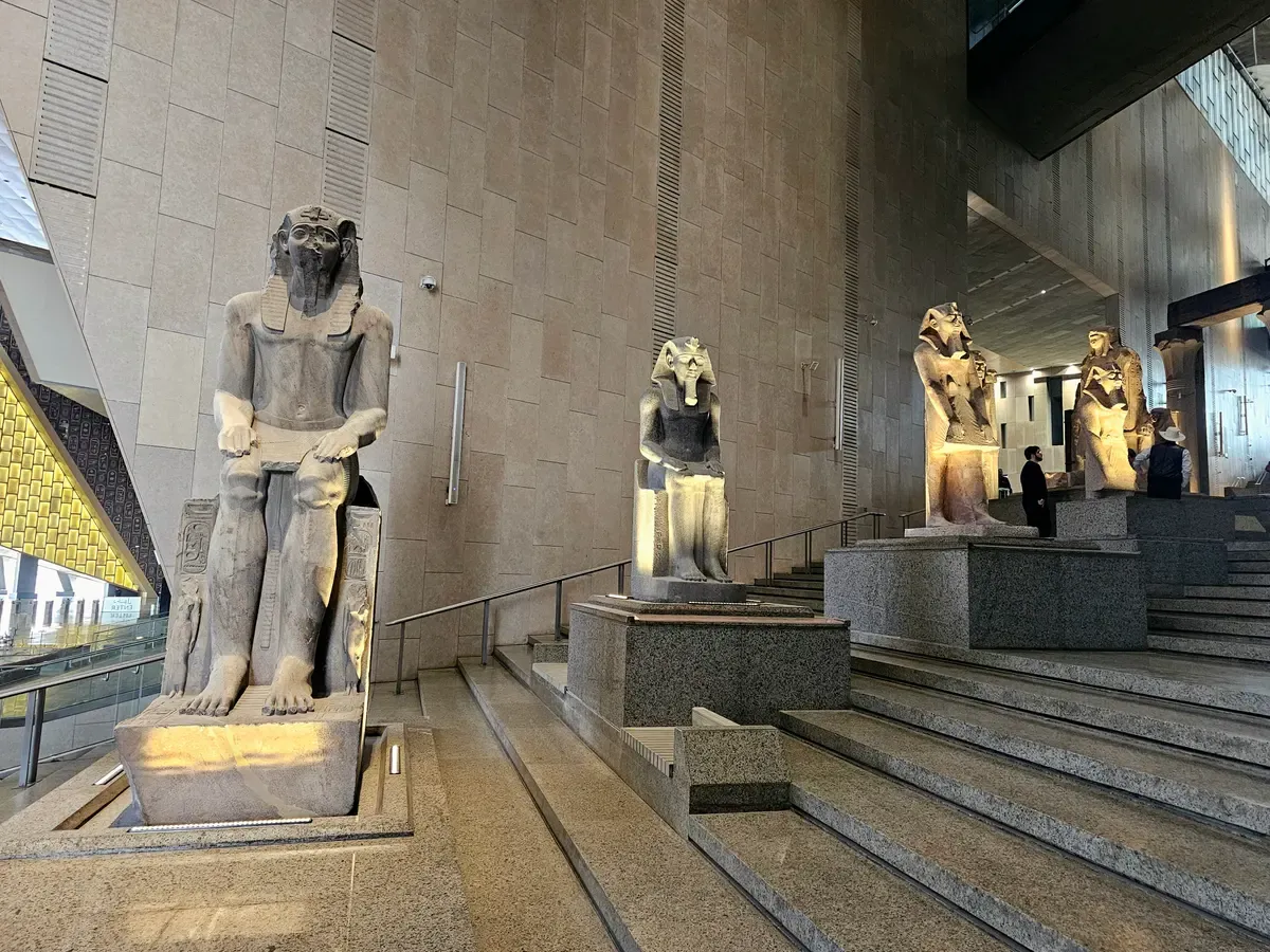 Colossal royal statues lining the Grand Staircase of the Grand Egyptian Museum on a luxury Egypt tour, Grand Egyptian Museum, Giza, Egypt