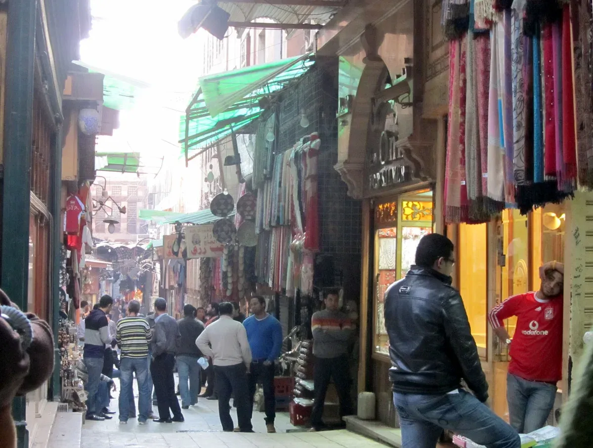 A busy bazaar lane lined with scarves and shops on a luxury Egypt tour, Khan el-Khalili, Cairo, Egypt