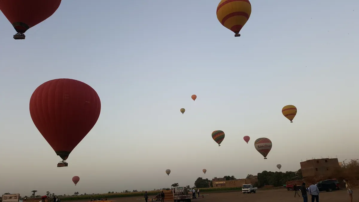 Hot air balloons rising over the west bank of Luxor at sunrise on a luxury Egypt tour