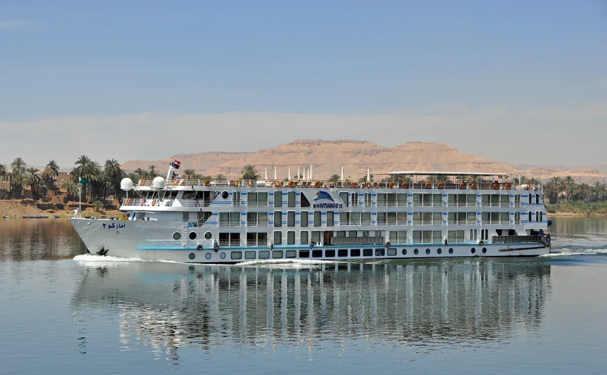 A Nile cruise ship sailing past the west bank hills near Luxor, the boat on most luxury Egypt tours