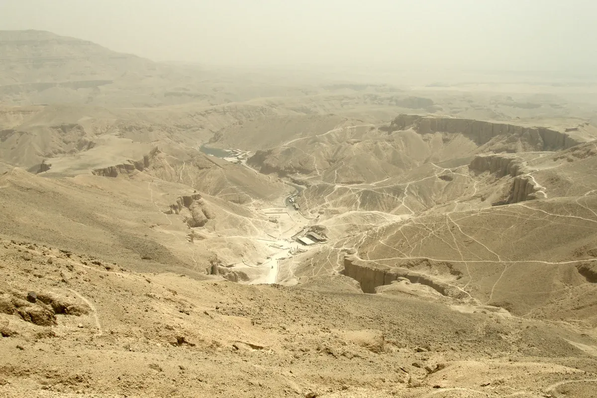 The dry desert valley and tomb entrances seen from the cliffs above on a luxury Egypt tour, Valley of the Kings, Luxor, Egypt